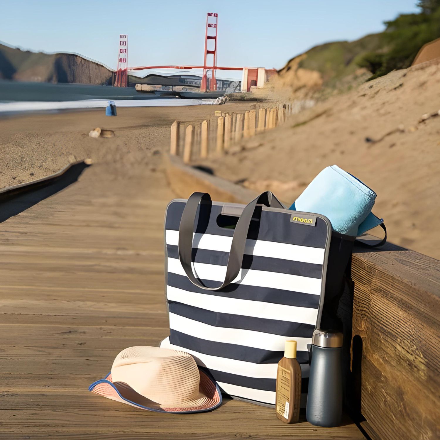 A100351-09-meori-Large-Utility-Tote-Marine-Blue-Stripes-LST large utlity tote at the beach with hat and sun tan lotion