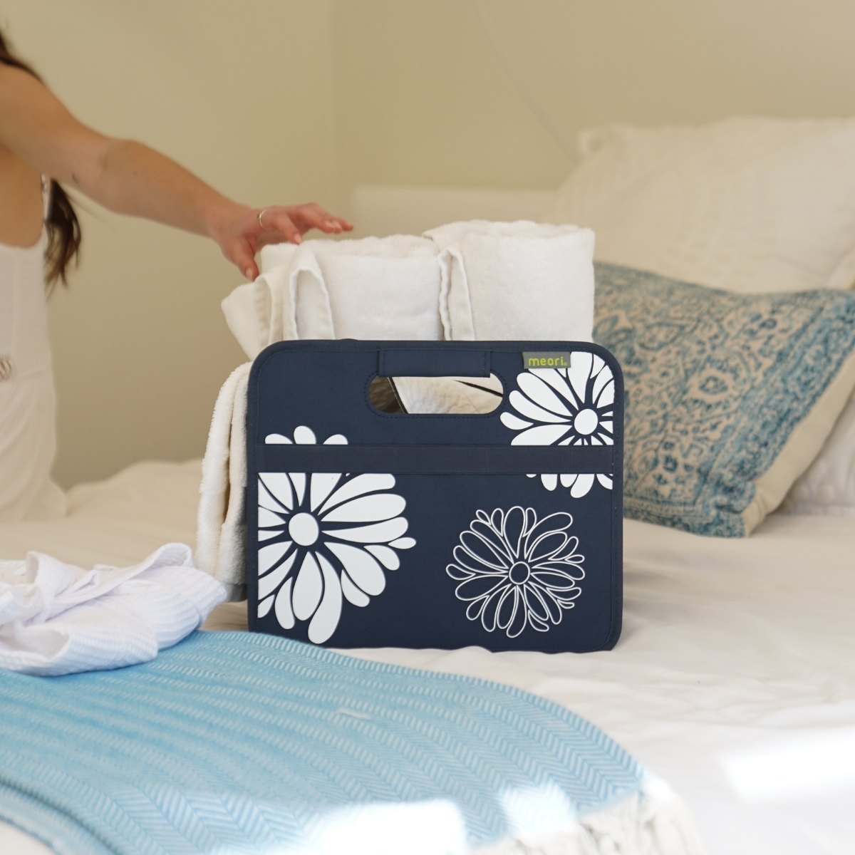 A100113-06-meori-Small-Foldable-Box-Marine-Blue-Flowers-LST Marine Blue Small Collapsible Storage Box with Flowers Imprint filled with towles on bed