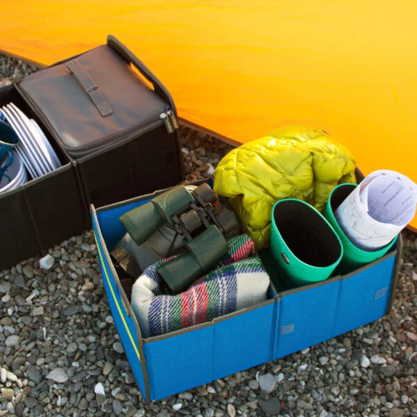 Black and Blue Collapsible Trunk Organizers shown holding various camping supplies in front of a tent