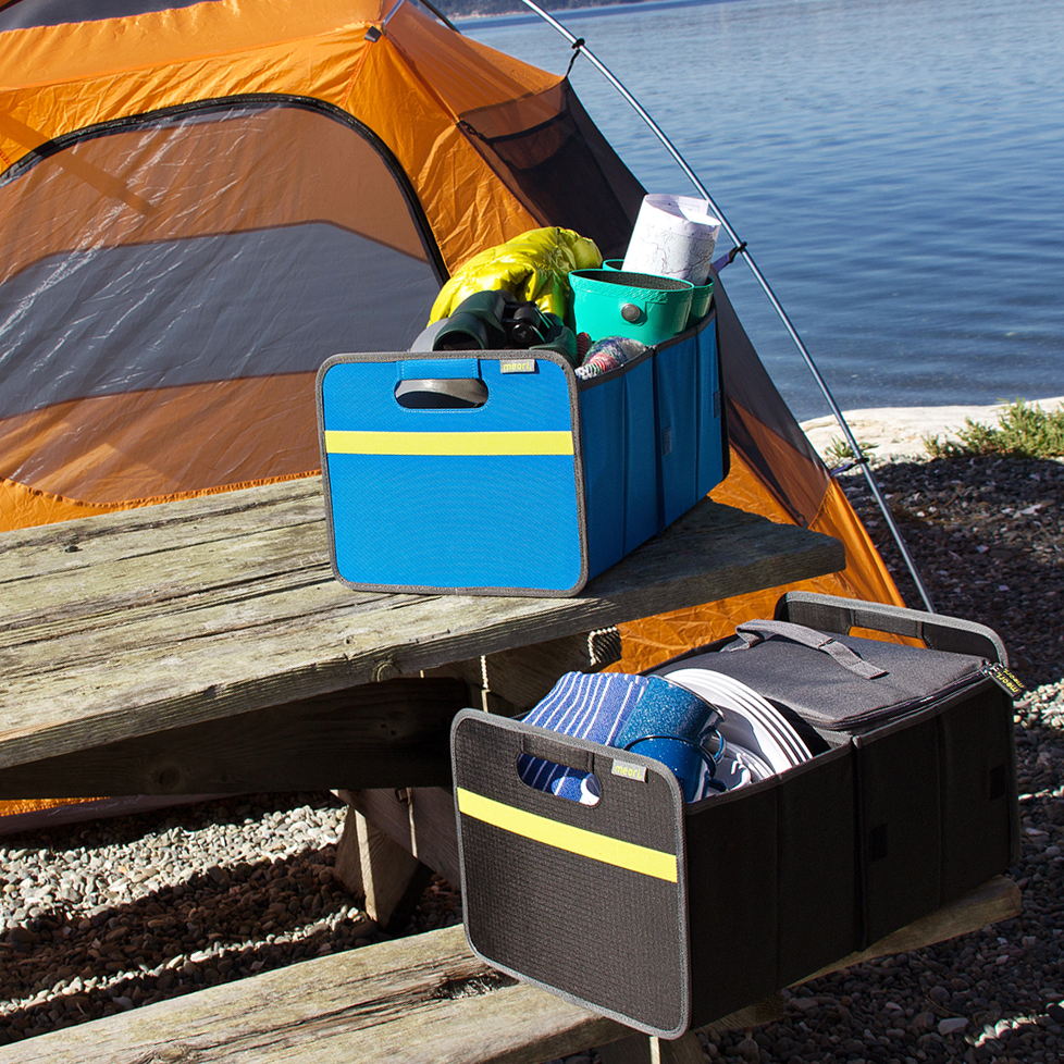 A100371-07-meori-Premium-Box-Med-Blue-LST Black and Blue Collapsible Trunk Organizers shown holding various camping supplies in front of a tent