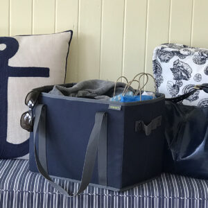 Marine Blue Collapsible Shopping Basket sitting on blue cushion in entry way
