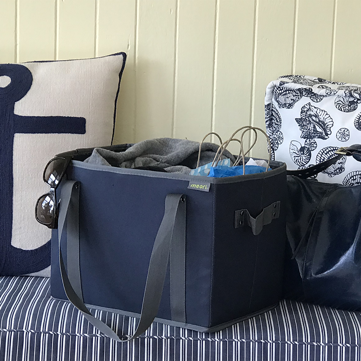 Marine Blue Collapsible Shopping Basket sitting on blue cushion in entry way