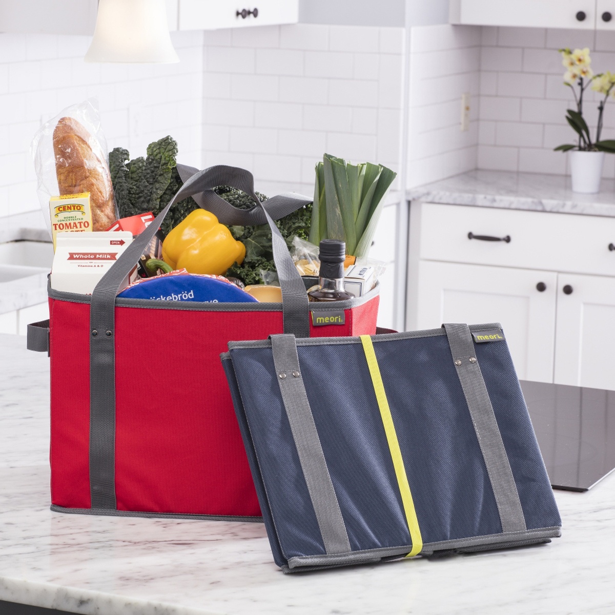 Red Blue Collapsible Shopping Basket filled with groceries and folded blue basket leaning against it