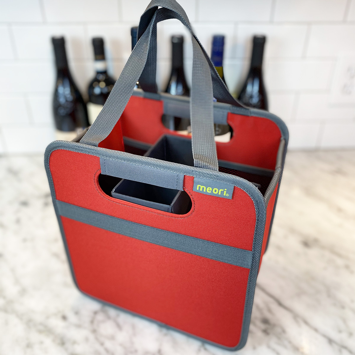 Empty Red 6 Bottle Wine Tote on kitchen counter in front of 6 wine bottles
