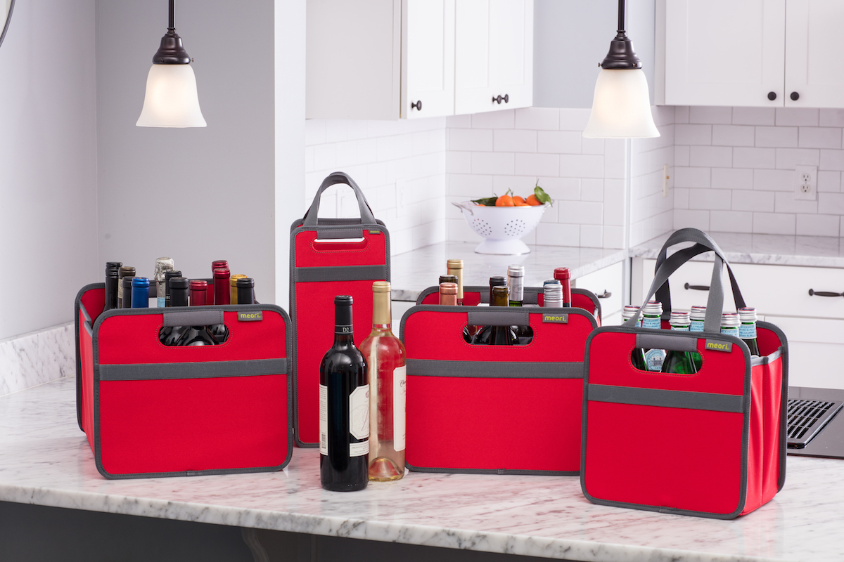 Group photo of various red Bottle Wine Totes filled with variety of bottles sitting on a kitchen counter