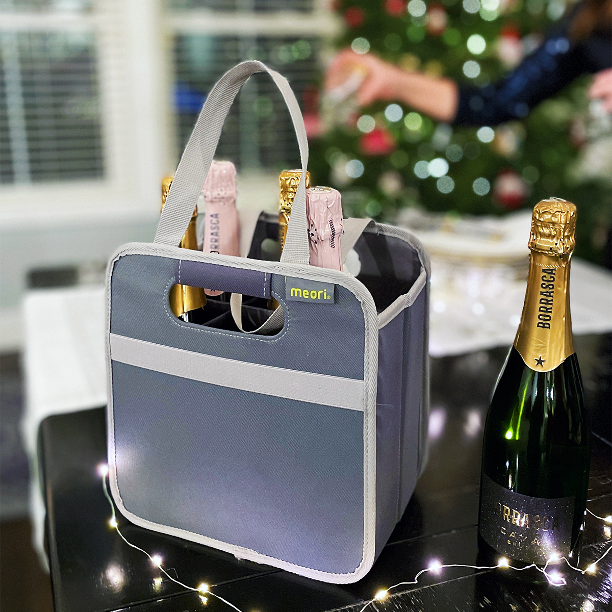 Grey 6 Bottle Wine Tote filled with bubblies on table in front of Christmas Tree