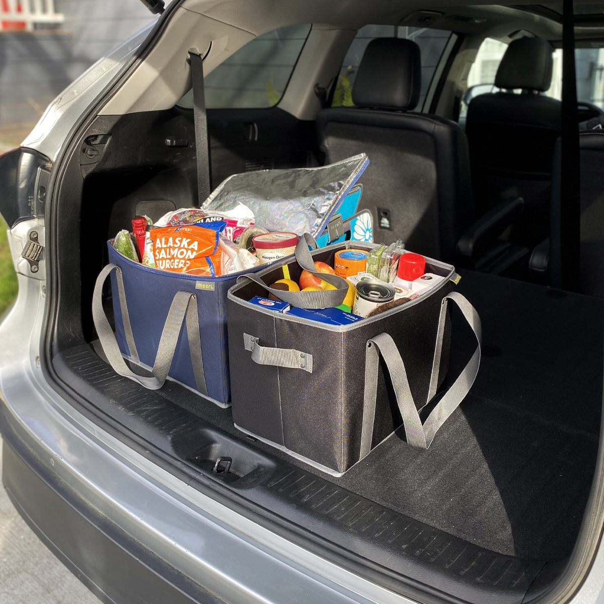 Marine Blue Insulated Grocery Bag With Zipper next to Grocery Basket shown in car trunk
