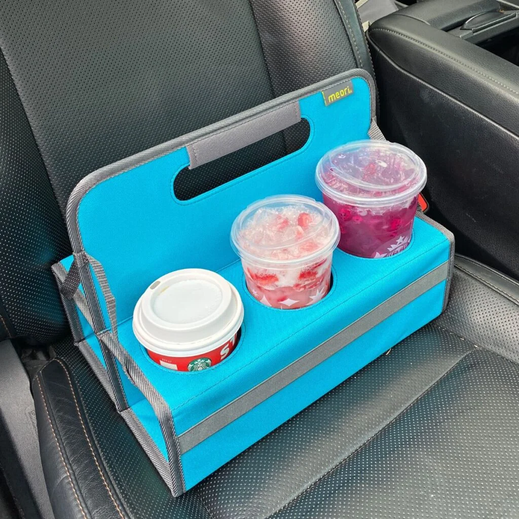 Azure Blue 6 Portable Drink Carrier with various coffee drinks on passenger-side car seat
