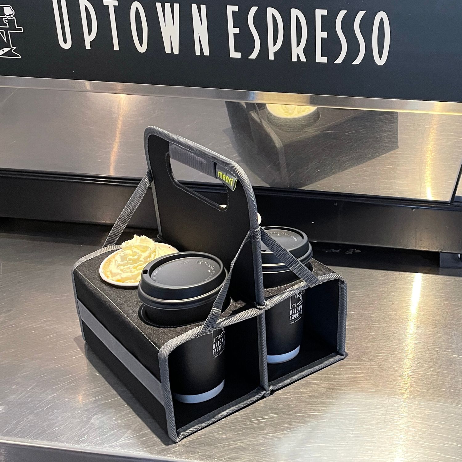 A100833-08-meori-Reusable-4-Cup-Carrier-Lava-Black-LST Black 4 Drink Caddy with four coffee drinks on espresso bar