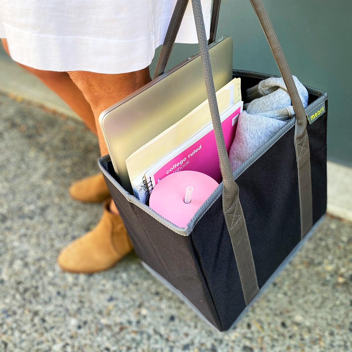 A100852-11-meori-Office-Tote-Lava-Black-LST Woman holding Black Office Tote Bag with work files and laptop