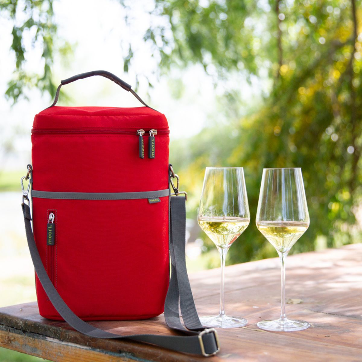 A100861-08-meori-Insulated-Wine-Tote-2-Bottles-Hibiscus-Red-LST Two White Wine Glasses next to zipped-up Red 2 Bottle Insulated Wine Bag