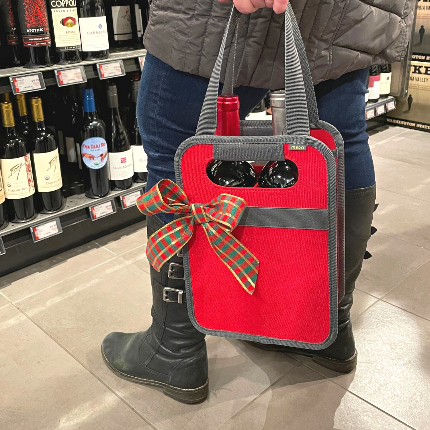 A100865-09-meori-2-Bottle-Wine-Tote-Hibiscus-Red-LST Woman holding a Red 2 Bottle Wine Carrier Tote with two bottles in wine store