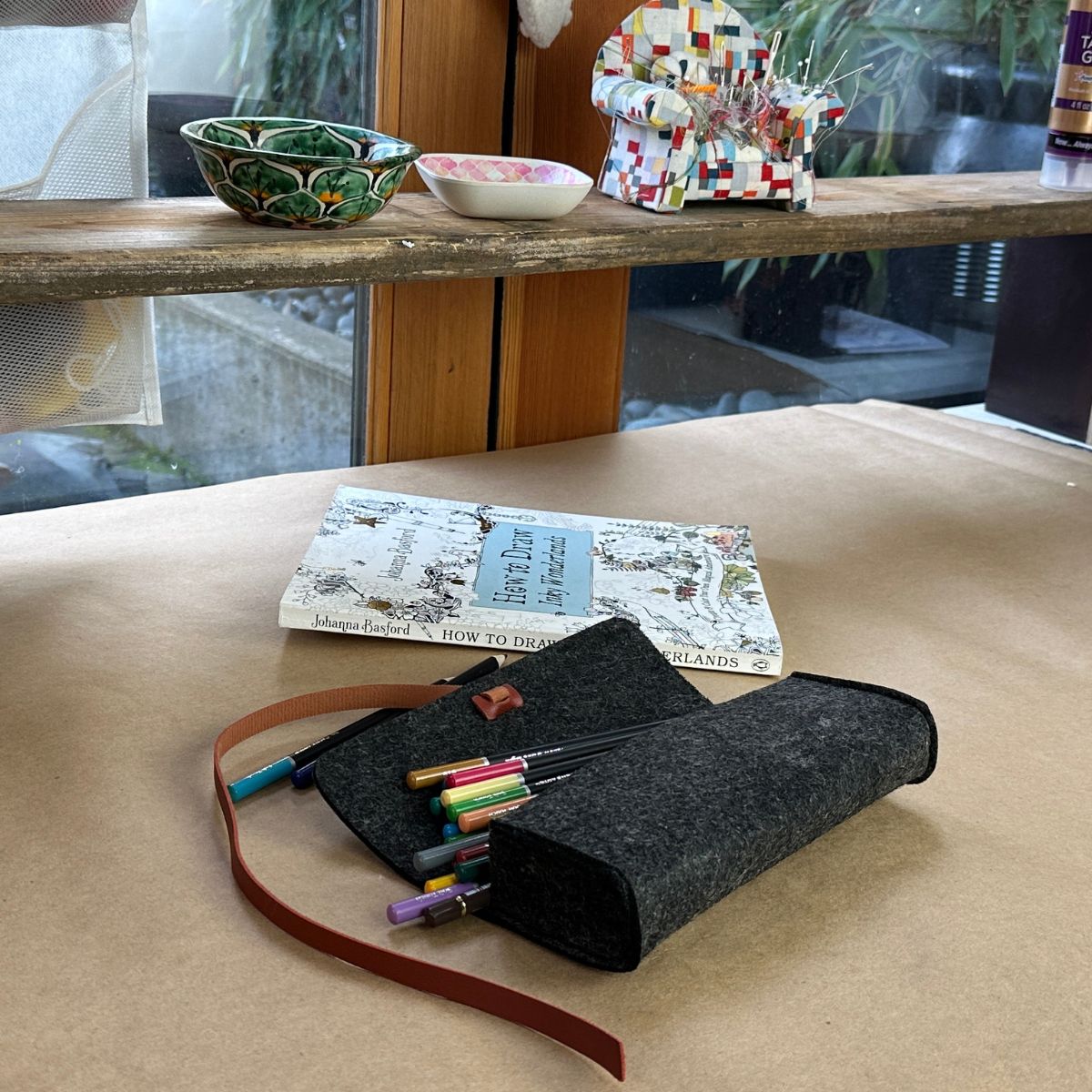 A100876-9-meori-Felt-Pouch-Anthrazite-Grey Open grey felt pouch with colorful pencil showing next to coloring book on craft table