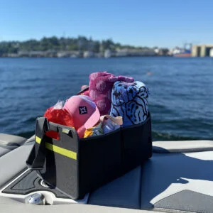 Black Trunk Organizer filled with towels and sun hat on the back of a boat