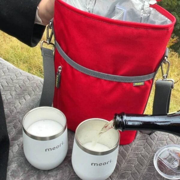 One of two insulated wine tumblers being filled with champagne in front of Red Wine Gift Bag